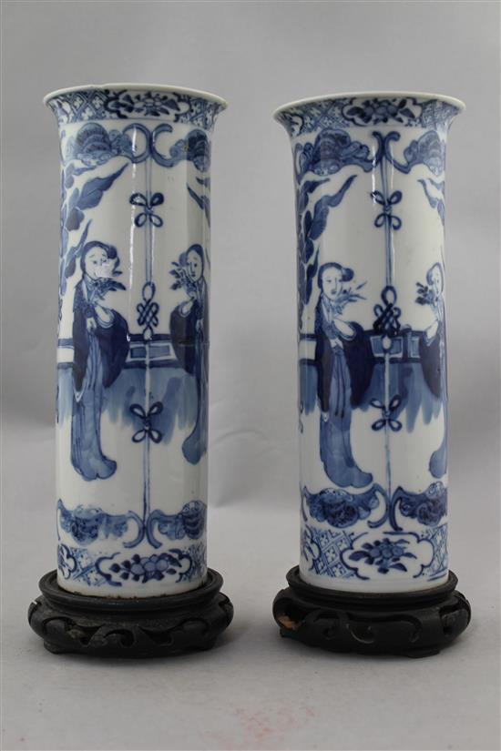 A pair of Chinese blue and white Long Eliza cylindrical vases, late 19th century, 26cm., ebonised wood stands